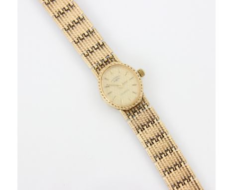 A 9ct yellow gold ladies Rotary wristwatch, the oval dial with baton markers, set grooved case, upon integral brick link brac