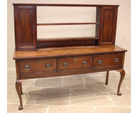 A George III oak dresser, the reduced plate rack with two open shelves flanked by spice cupboards, upon the rectangular cross