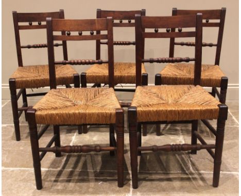 A set of five Regency fruitwood country chairs, each with a bobbin turned rail back over an envelope rush seat, upon ring tur