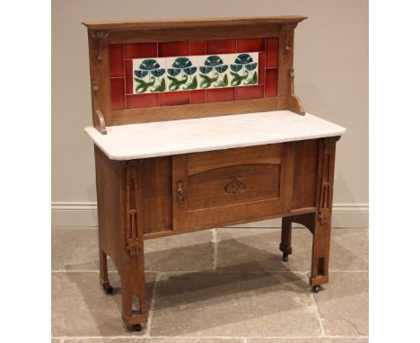 A honey oak tiled back Arts and Crafts washstand, in the manner of Liberty &amp; Co, early 20th century, the raised back inse