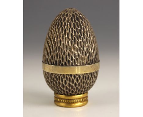 A Stuart Devlin silver gilt surprise-egg, London 1976, No. 188, the textured egg opening to reveal gilt interior and figure o