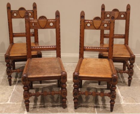 A set of four pitch pine ecclesiastical hall/side chairs, late 19th/early 20th century, the rail backs centred with shield an