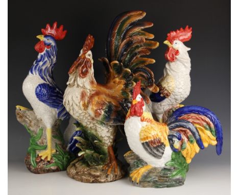 Four large ceramic cockerels, 20th century, each polychrome enameled and modelled on a naturalistic ground, smallest 35cm hig