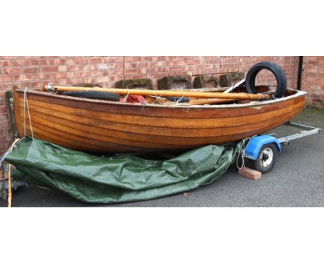 A vintage wooden sailing dinghy, of planked construction, the hull 365cm long, the removable mast measuring 337cm overall, wi