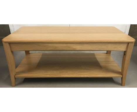 A modern light wood Ercol coffee table with tapered legs and undershelf.  Approx. 100.5cm L x 51cm W x 42cm T.