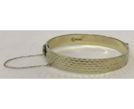 A vintage silver gilt bangle with engine turned decoration and safety chain. Hallmarked London 1966. Total weight approx. 23.