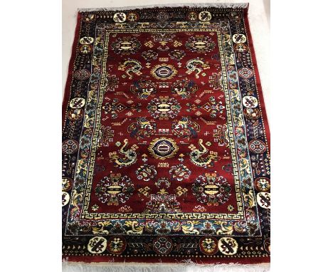 A red ground vintage Oriental style rug decorated with dragon and Phoenix design. With blue, cream and gold detail and with t