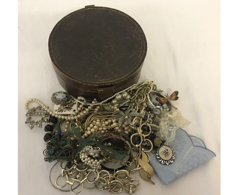 A vintage leather collar box containing a quantity of assorted costume jewellery. To include: brooches, scarf ties, necklaces
