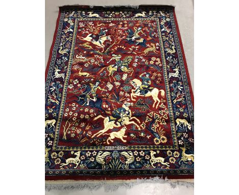 A red ground vintage Persian style rug with hunting scene detail. Animal, bird and foliate design to border. With tassled end