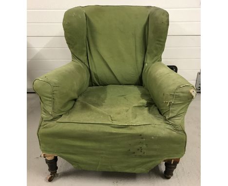 A vintage armchair with turned wooden legs and ceramic castors ( I missing). Restoration project.  