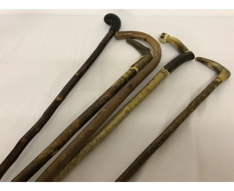 A collection of 5 vintage wooden walking sticks to include horn handled.  