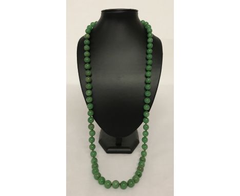 A 34" jade beaded necklace, knotted between each bead.  Beads approx. 1.25cm diameter.
