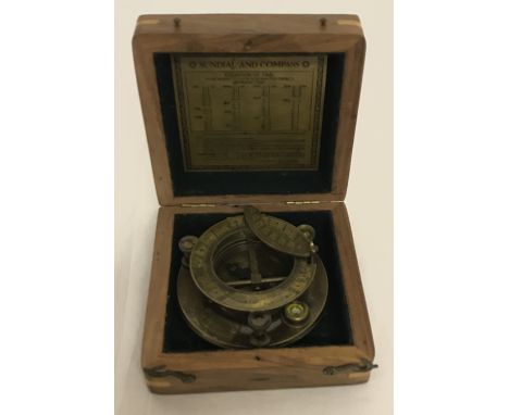 A brass sundial and compass in wooden box. Box and dial both marked "J.H.Steward Ltd, London". Box approx. 13.5cm x 14cm x 5.