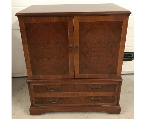 A vintage cherry coloured wooden 2 drawer, 2 door cabinet. On casters. Approx. 92cm tall x 77.5cm wide.