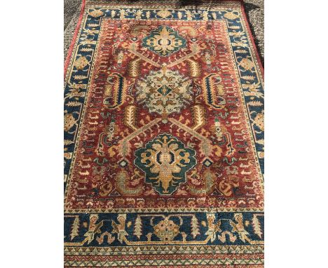 A vintage rug of 100% New Zealand wool. In rich coloured pattern with maroon border and fringed ends. Approx. 230 x160cm.