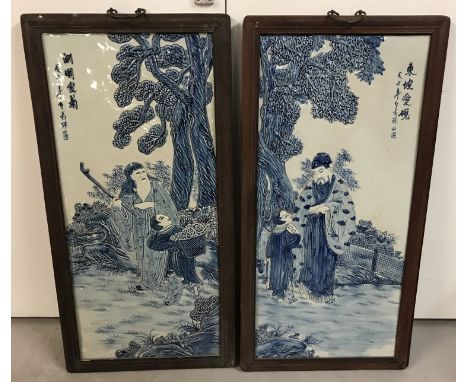 A pair of large blue and white Chinese ceramic, wall hanging plaques, signed to fronts. In wooden frames. Approx. 89cm x 45cm
