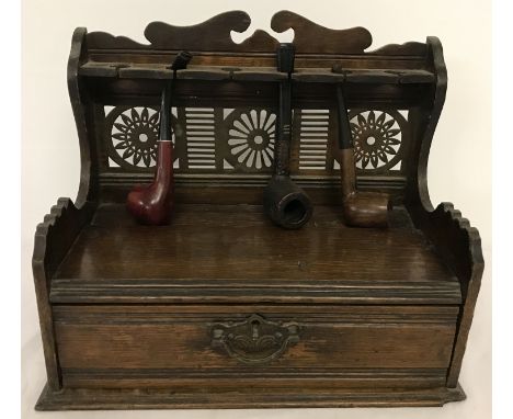 A vintage dark wood pipe rack cabinet with decorative drop down handle and metal pierced work panel.  Approx. 25cm tall x 30c