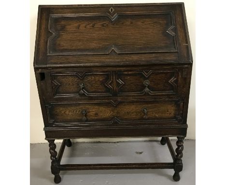 A vintage dark wood bureau with interior stationery compartments. Barley twist legs and detailing to drawers and pull down fr
