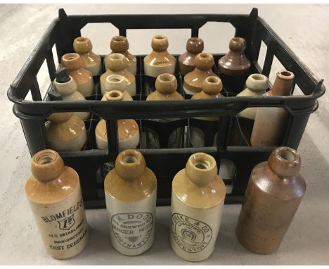 A crate containing 20 vintage stoneware ginger beer bottles, many with advertising. To include: Caleys of Norwich, Blomfield'