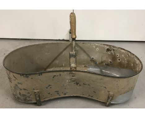A vintage galvanised metal trough/feeder with wooden handle.  Approx. 62cm wide x 36 cm tall including handle.