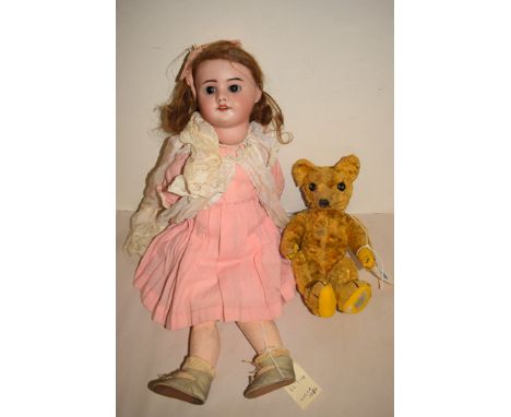 A French SFBJ bisque headed doll, model 60, size 5, glass sleeping eyes, composite body; and an early 20th Century teddy bear
