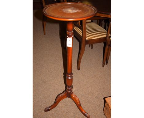 A reproduction stained mahogany circular jardiniere stand inset leather top, raised on tripod feet; and a modern brass standa