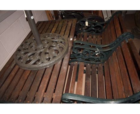 Garden furniture: green painted cast metal and wooden slatted table, two chairs and a bench; another metal bench; and an umbr