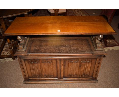 An early 20th Century stained oak monk's bench, by L. Marcus Ltd., London, the back with carved leaf and crest decoration, li