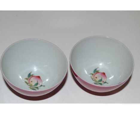 Chinese Porcelain Ruby/Pink Monochrome Bowls, probably Qing dynasty each enamelled to the interior with a peach (2)8cm diamet