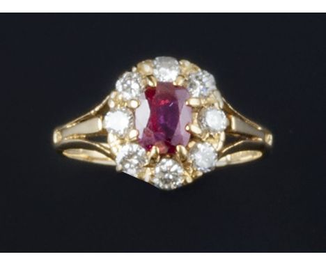 A ruby and diamond cluster ring, the oval mixed-cut ruby claw set within a border of brilliant-cut diamonds, between trifurca