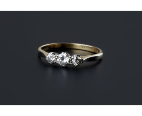 A diamond three stone ring, claw set with graduated brilliant and old-cut diamonds, two colour precious metal mounted, ring s