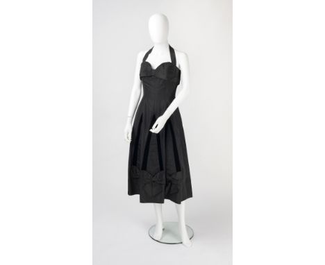 Two black evening dresses, the first a halter-neck dress, with pleated bow detail to the bodice and velvet trimmed skirt, Fem