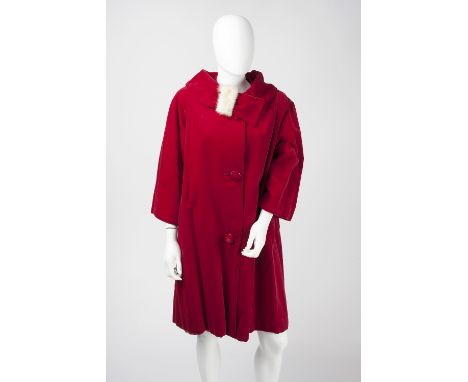A red velvet coat, with asymmetric fur trimmed collar, button detail to front and bracelet length sleeves, and a further gree