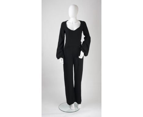 An Alexander McQueen black jump suit, deep round neckline, pockets and button detail to waist, cuffed full length sleeves, fl