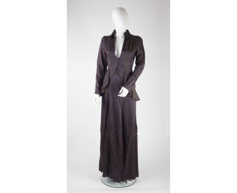 An Ossie Clark 1970s two-piece flounced blouse and skirt suit, of dark purple hue, the blouse with full length sleeves with b