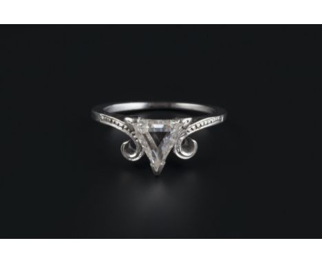 A diamond single stone ring, the triangular step-cut diamond claw set between scrolled shoulders, white precious metal mounte