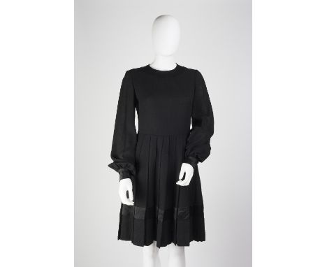A black dress with pleated skirt, with full length sleeves, button detail to cuffs and back, the round neckline, back, skirt 