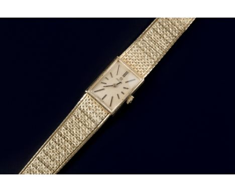 A lady's 18ct gold bracelet watch by Omega, the rectangular signed brushed gilt dial with baton markers, to manual movement a