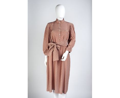 A light pink Jean Muir silk dress with repeated cream flower motif, round neck, full length cuffed sleeves and button detail 