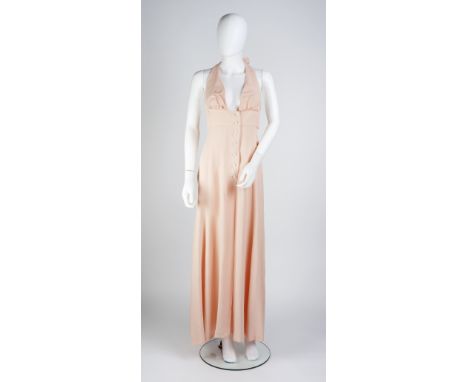 An Ossie Clark full length pale peach backless dress, with v-shaped halter neck, button detail to front and zip fastening to 