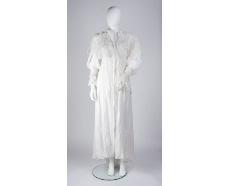 A white peignoir, with white lace panels and trim, pockets to front and button fastening to back