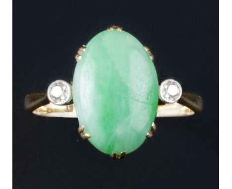 A jade and diamond dress ring, the oval cabochon jade claw set between two old-cut diamond highlights, to shank stamped '18ct