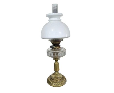 A Victorian oil lamp with faceted clear glass reservoir, decorative brass base and white glass shade, height to top of shade 