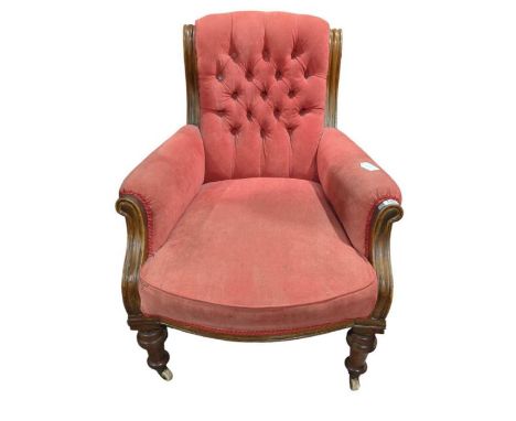 A Victorian walnut framed button back easy chair with turned front supports
