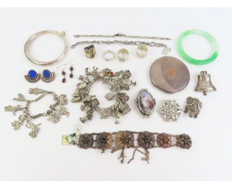 A ceramic panel brooch, set with diamonds; a silver charm bracelet and charms; a silver compact and various other silver and 