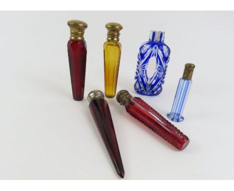 A Victorian amber glass scent bottle of faceted, tapering form with gilt metal hinged cover, 10cm; three ruby glass scent bot