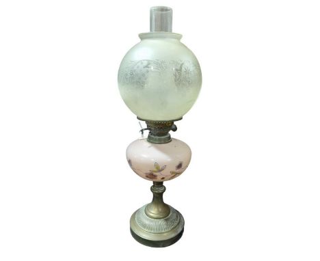 A late 19th/early 20th century oil lamp having floral painted pink glass reservoir and brass base with etched glass shade, he