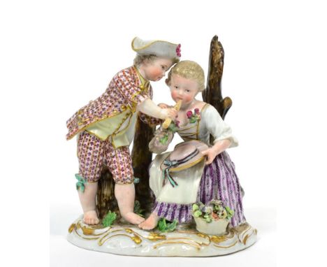 A Marcolini Meissen Porcelain Figure Group, circa 1780, as a boy holding a pipe to the lips of a seated girl, on a scroll mou