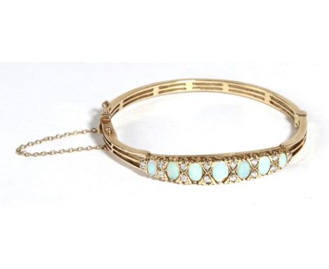 A 9 Carat Gold Opal and Diamond Bangle, seven graduated oval cabochon opals spaced by pairs of round brilliant cut diamonds, 