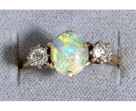 An Opal and Diamond Three Stone Ring, an oval cabochon opal in a claw setting, between old cut diamonds in collet settings, t